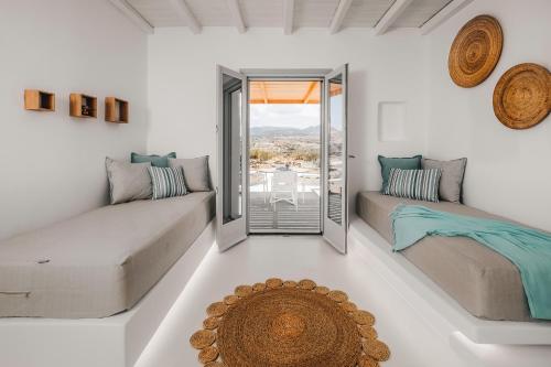 a living room with two couches and a large window at Xerolithos Natural Living in Naxos Chora