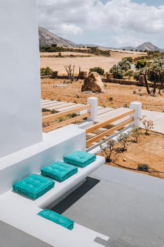 a white bench with blue cushions on it in the desert at Xerolithos Natural Living in Naxos Chora