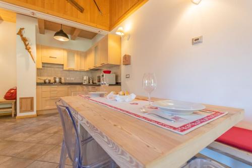 a kitchen with a wooden table with a wine glass at Villa Edelweiss in Alleghe