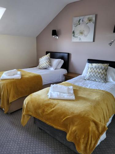 a hotel room with two beds with towels on them at The Stores in Aberystwyth