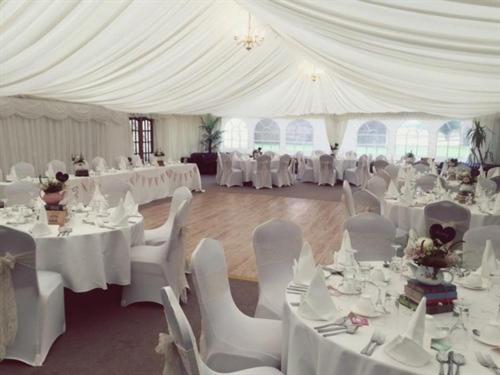 a white tent with tables and chairs in a room at The Sibson Inn Hotel in Water Newton