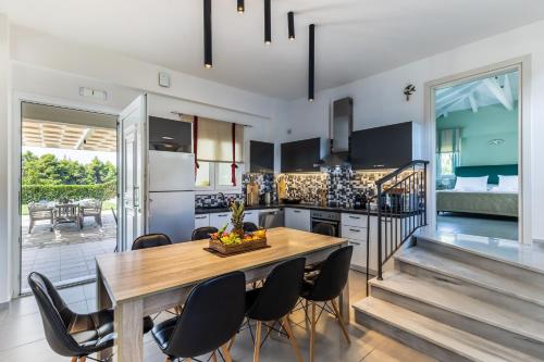 a kitchen and dining room with a table and chairs at Villa Aelia by Kardous in Alikias