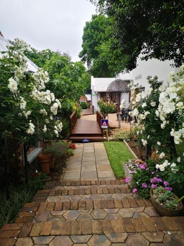 a garden with a walkway with flowers and plants at Van Dykshuis Guest House in Heidelberg