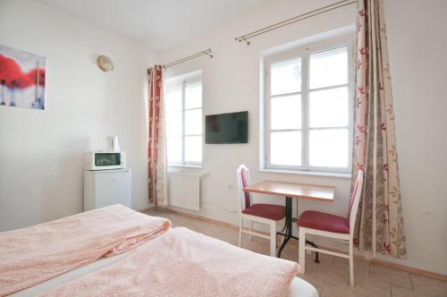 1 dormitorio con escritorio, 1 cama y 1 mesa en Borbarátok Háza en Győr