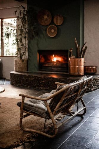 a rocking chair in a living room with a fireplace at Linvale Country Lodge in Hazyview