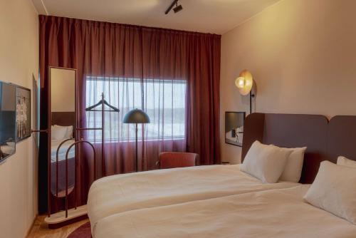 a hotel room with a large bed and a window at Scandic Landvetter in Landvetter