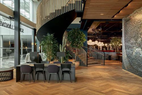 een restaurant met tafels en stoelen en een trap bij Scandic Landvetter in Landvetter