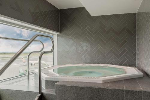 a jacuzzi tub in a room with a window at Scandic Landvetter in Landvetter