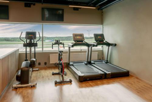 a gym with three exercise bikes in front of a window at Scandic Landvetter in Landvetter