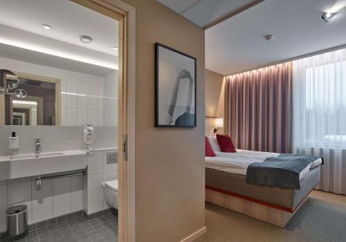 a hotel room with a bed and a bathroom at Scandic Arlandastad in Arlanda
