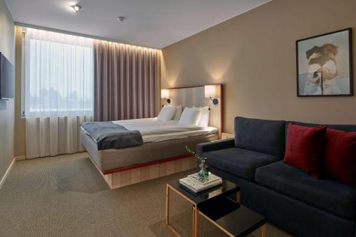 pokój hotelowy z łóżkiem i kanapą w obiekcie Scandic Arlandastad w mieście Arlanda
