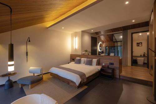 a bedroom with a large bed and a bathroom at Yangshuo Hillside Homestay in Yangshuo