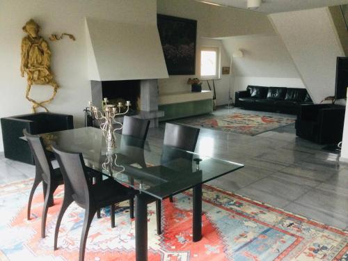 a dining room with a black table and chairs at Einzigartige Penthauswohnung in Nuremberg