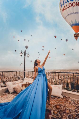 a woman in a blue dress with a hot air balloon at Mak's Cave House in Uchisar