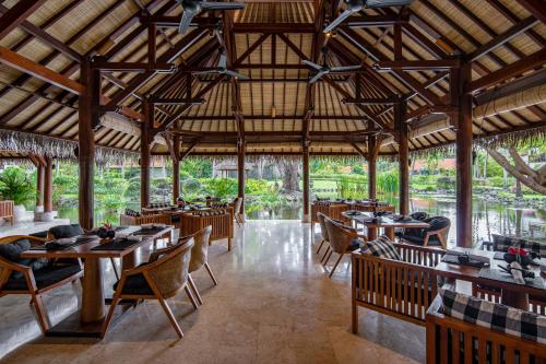 a dining room with wooden tables and chairs at Grand Hyatt Bali in Nusa Dua