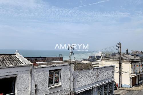 a view of roofs of buildings with the ocean in the background at AS 50 - Les bateaux au bord de l'eau in Ault