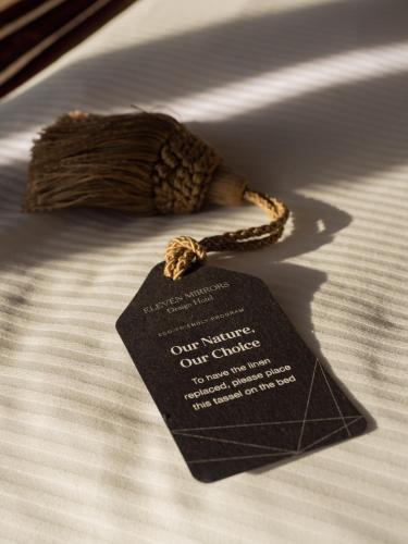 a black tag on a rope on a bed at 11 Mirrors Design Hotel in Kyiv