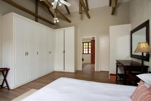 a bedroom with a bed and a desk in a room at Whispering Pines Country Estate in Magaliesburg
