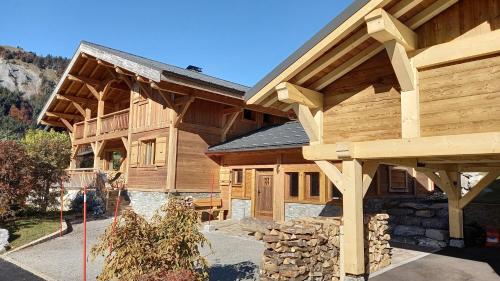 ein Blockhaus mit einem großen Holzdach in der Unterkunft Chalet La Canopée in La Giettaz