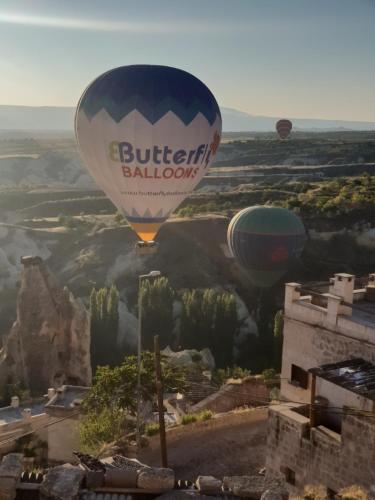 a hot air balloon is flying over a valley at Mak's Cave House in Uchisar