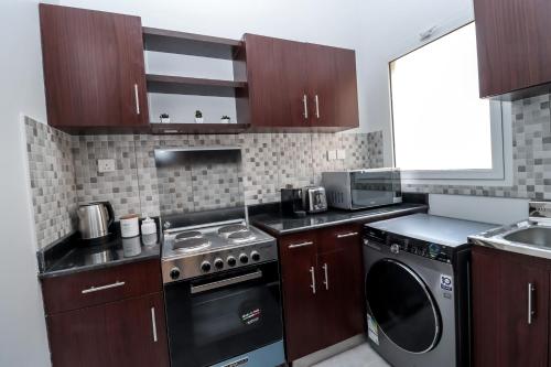 a kitchen with a stove and a dishwasher at Mabaat - Al Shurooq 10 - 90 in King Abdullah Economic City
