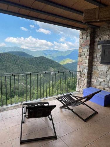 a patio with a chair and a table and a view at Mas merolla casa para descanso familiar in Gombreny