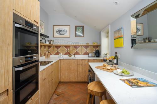 cocina con armarios de madera y encimera en The Nook at Henge Estate, en Salisbury