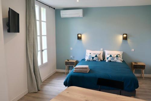 Dormitorio azul con cama con sábanas y almohadas azules en Moulin 1- Appartement Arènes Romaines - Beziers centre - Wifi - Tv connectée en Béziers