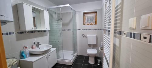 a white bathroom with a sink and a shower at Ellen-Lara in Jasenak