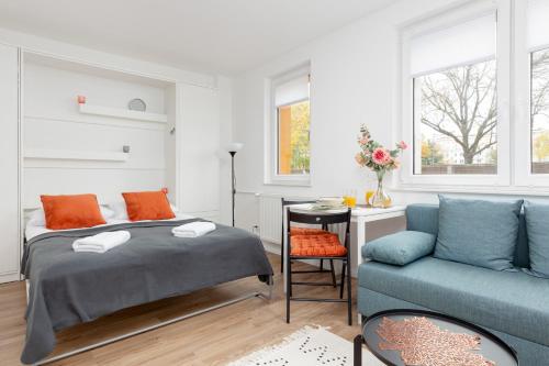 1 dormitorio con 1 cama y 1 sofá azul en Studio Apartment Ochota Siemieńskiego by Renters, en Varsovia