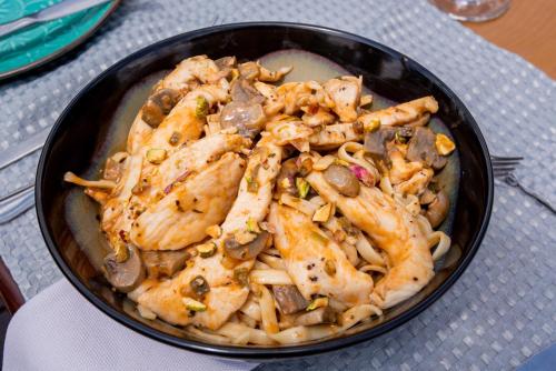 a bowl of food with chicken and mushrooms on a table at Whispering Pines Country Estate in Magaliesburg