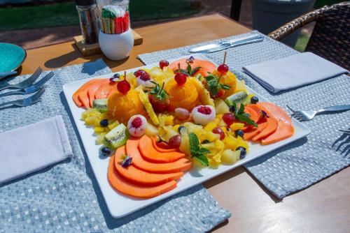 a plate of fruit and vegetables on a table at Whispering Pines Country Estate in Magaliesburg