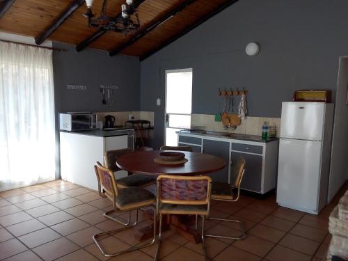 a kitchen with a table and chairs and a refrigerator at Bateleur Nature Reserve in Modimolle
