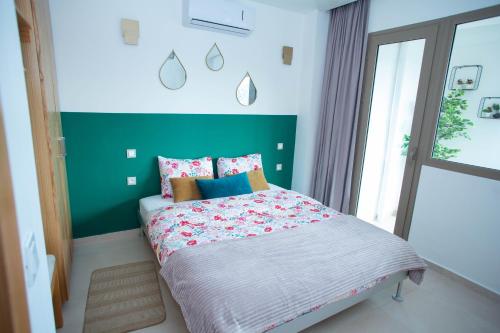 ein Schlafzimmer mit einem Bett mit einer grünen Wand in der Unterkunft My Cosy Place Rabat - Appartements à 50m de la gare Agdal TGV in Rabat
