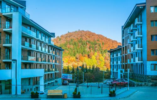 un gruppo di edifici con una montagna sullo sfondo di Orbi Palace Hotel Official a Bakuriani