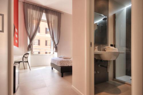 La salle de bains est pourvue d'un lavabo, d'un lit et d'une fenêtre. dans l'établissement Manin Suites LT, à Rome