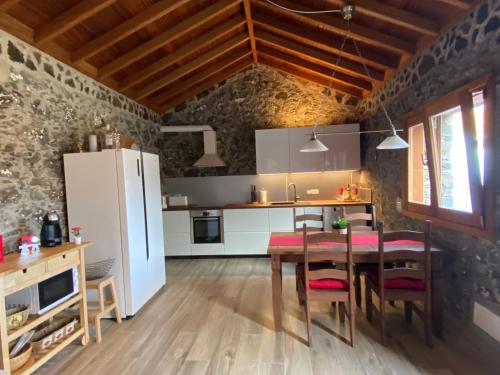 a kitchen with a table and a white refrigerator at Casa Sol in Hermigua