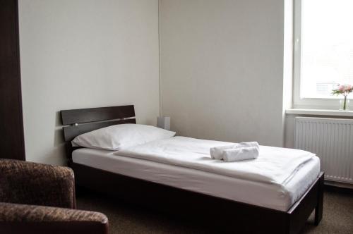 a bed sitting in a room with a window at Penzión Pohoda in Nové Zámky