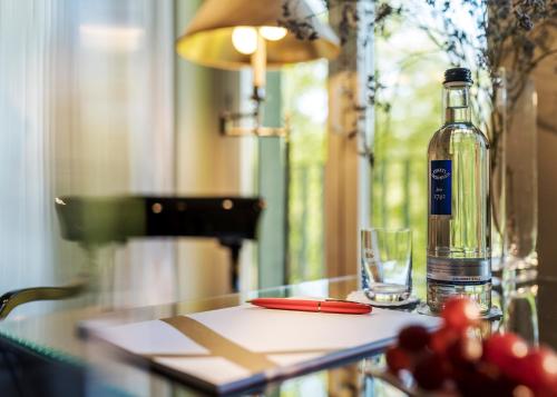 a bottle of wine sitting on a table with a glass at Parkhotel Bremen – ein Mitglied der Hommage Luxury Hotels Collection in Bremen
