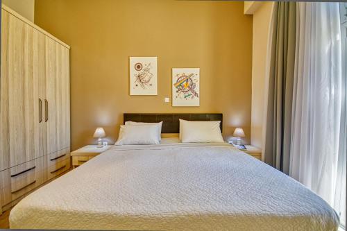 a bedroom with a large bed with two tables and two lamps at Island Boutique Hotel in Rhodes Town