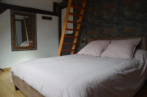 1 dormitorio con 1 cama con escalera y espejo en Le Relais du Biau Ri en famille ou entre amis, en Clairfayts