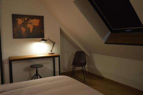a bedroom with a desk and a bed and a lamp at Le Relais du Biau Ri en famille ou entre amis in Clairfayts