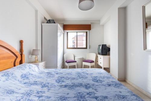 a bedroom with a bed and two chairs at Fuengirola City Centre Apartment in Fuengirola