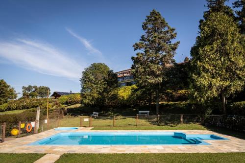 a swimming pool in the yard of a house at Hotel Bangalôs da Serra in Gramado