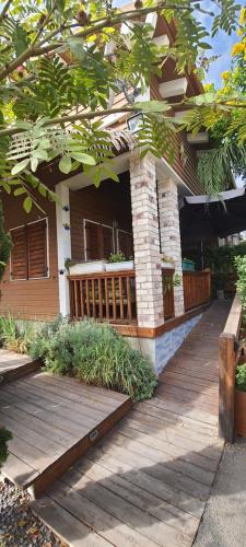 a porch of a house with a wooden deck at The Butterflies Wood House in Reshafim