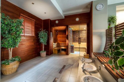 uma casa de banho com dois lavatórios e vasos de plantas em Atrium Apartamenty em Sarbinowo