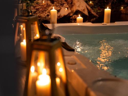 a bath tub with candles and lights in it at Atrium Apartamenty in Sarbinowo