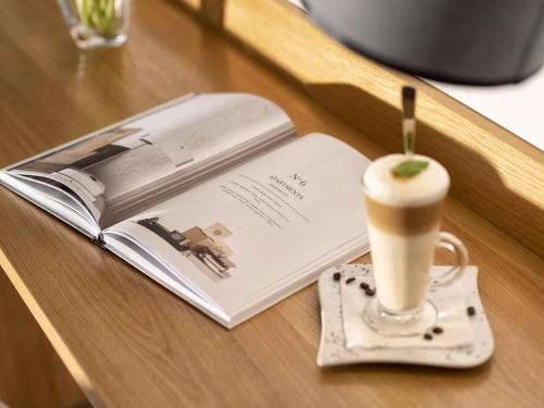 a book and a cup of coffee on a table at Atrium Apartamenty in Sarbinowo