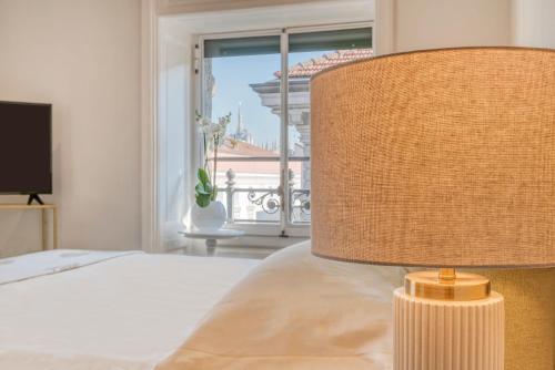 a bedroom with a bed with a lamp and a window at Imperiale Suites Milano in Milan