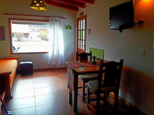 een eetkamer met een tafel en stoelen en een raam bij Cabañas Paso de Viento in El Chalten